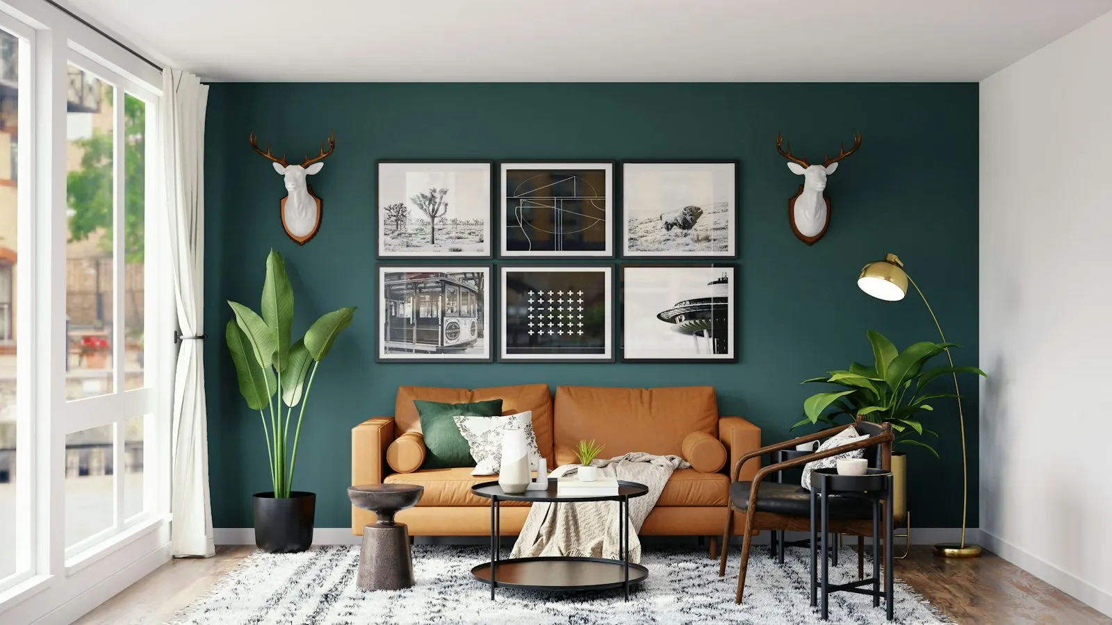 Emerald-green living room wall behind camel leather seating, gallery frames and a tripod lamp